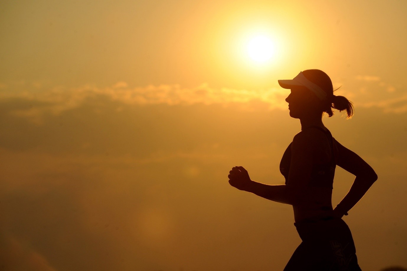 Silhouette of a woman runner against a sunset